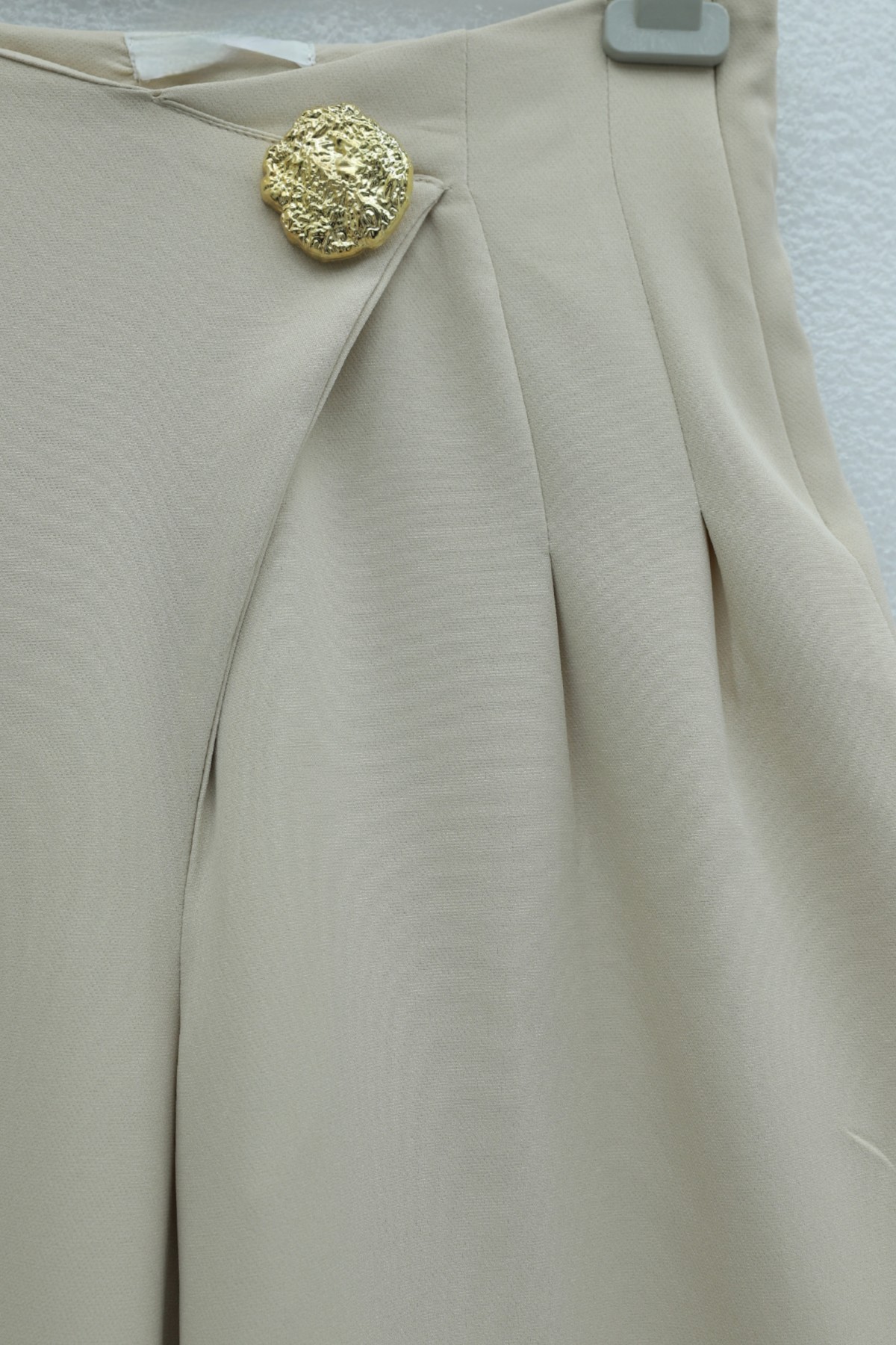 Wide-leg crepe trousers with side zipper, brooch, and folding detail. - Beige