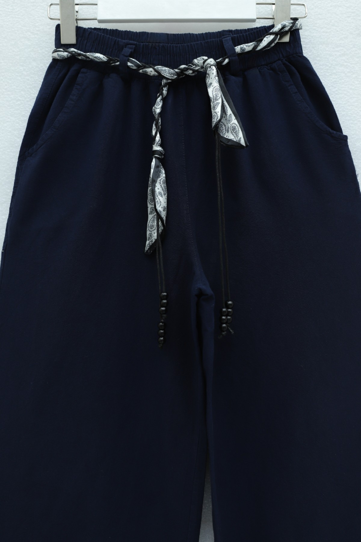 Wide-leg linen trousers with elasticated waist, belt, and pockets. -Navy blue
