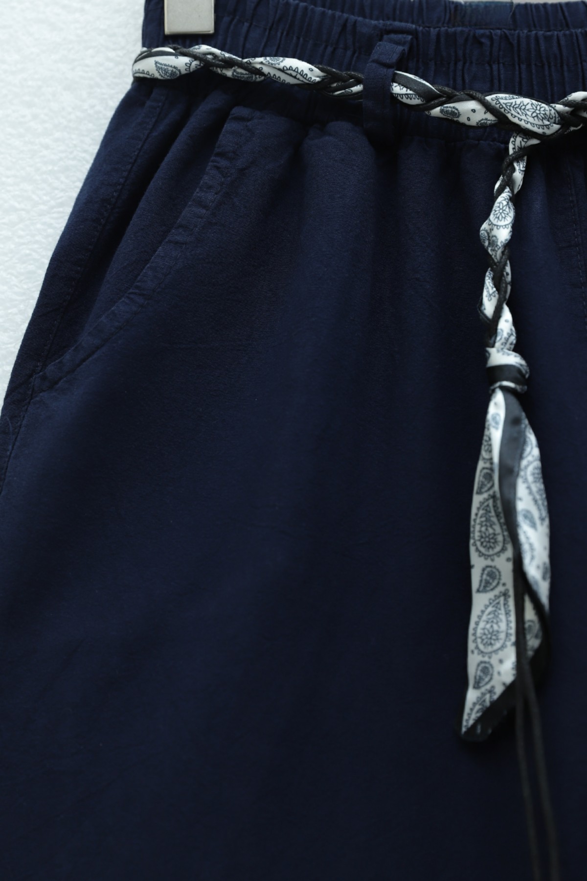 Wide-leg linen trousers with elasticated waist, belt, and pockets. -Navy blue