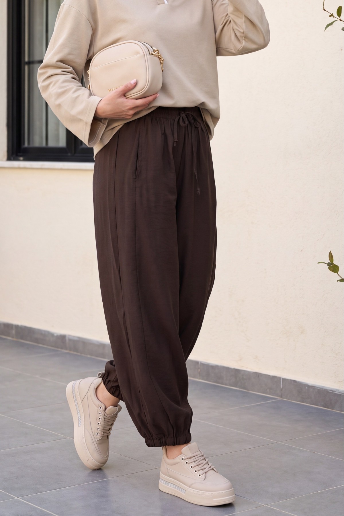 Modal trousers with elasticated waistband, pockets, and drawstring. -Brown