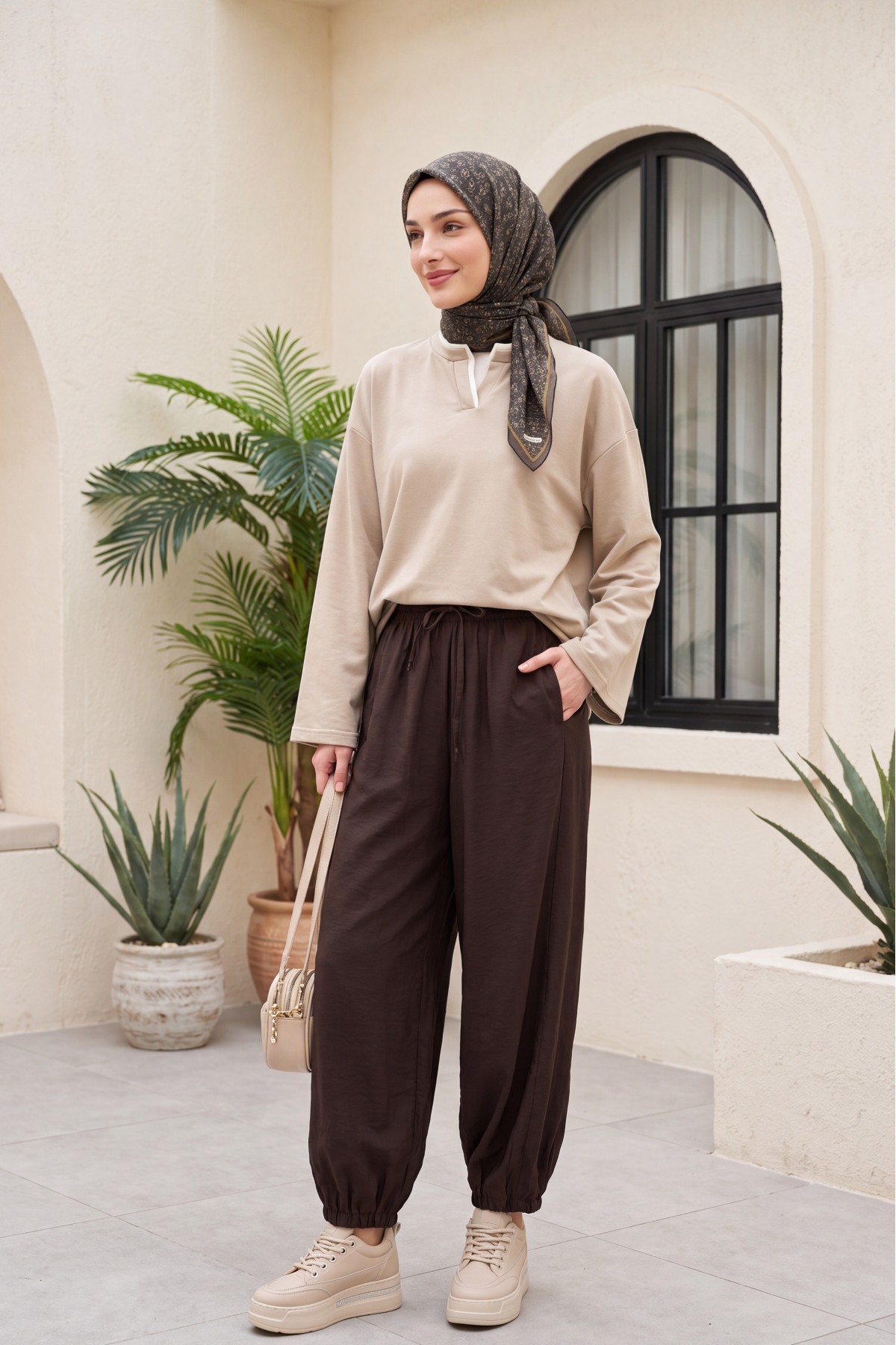 Modal trousers with elasticated waistband, pockets, and drawstring. -Brown