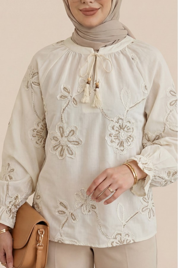 Long-sleeved blouse with tassel detail and floral embroidery. -Cream color
