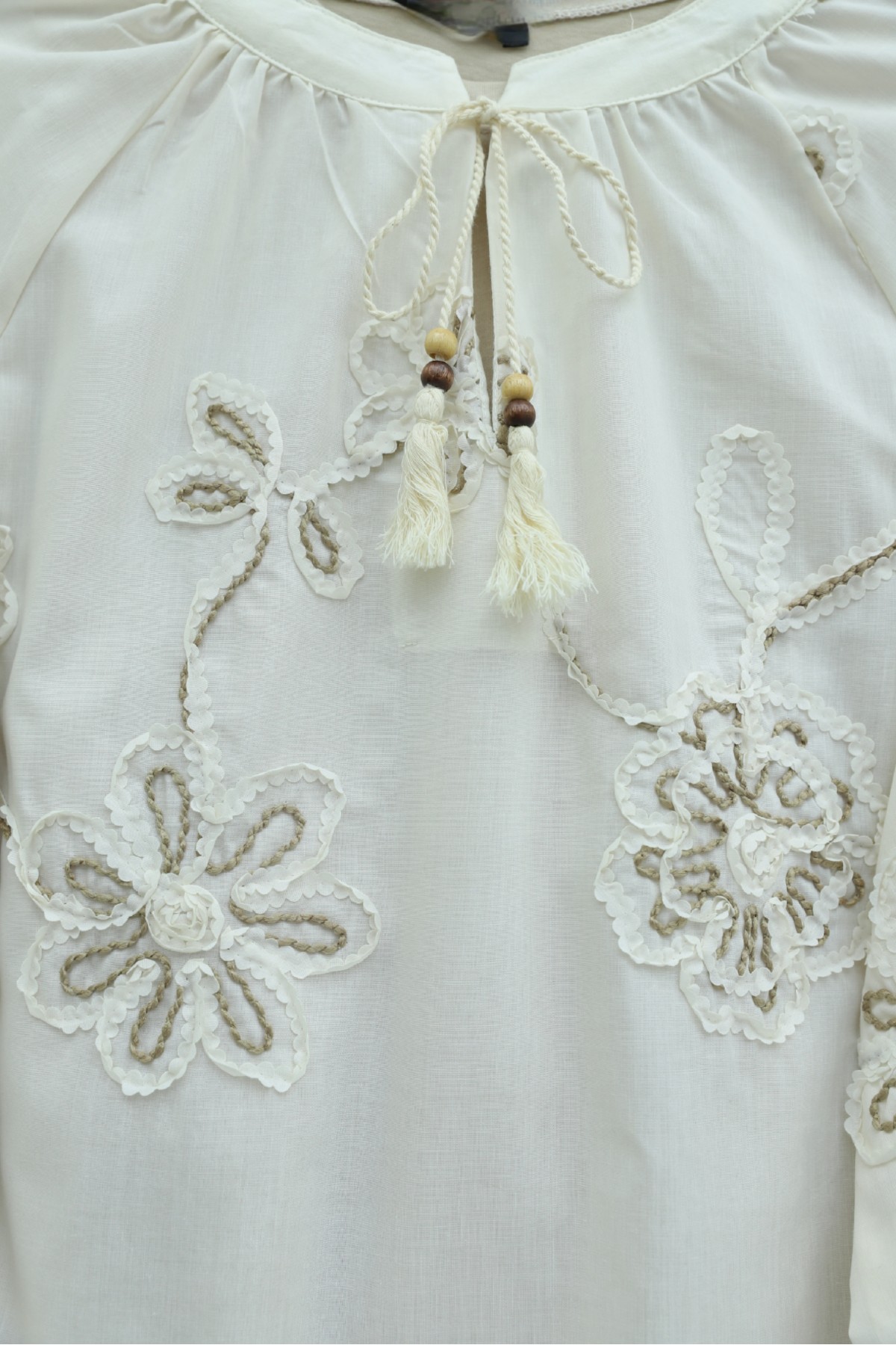 بلوزة بأكمام طويلة مزينة بشرابة وتطريز زهري. -لون كريمي