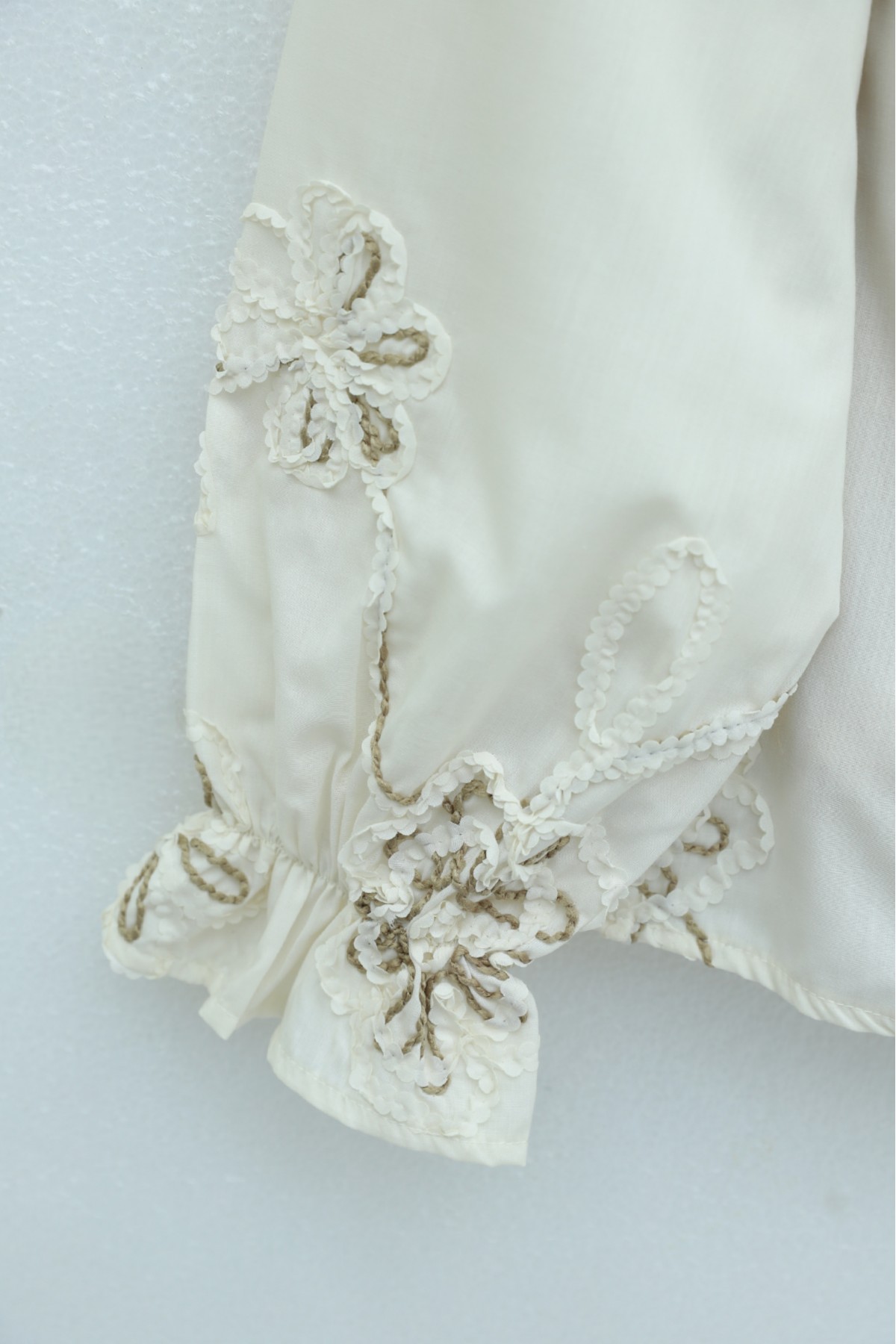 بلوزة بأكمام طويلة مزينة بشرابة وتطريز زهري. -لون كريمي