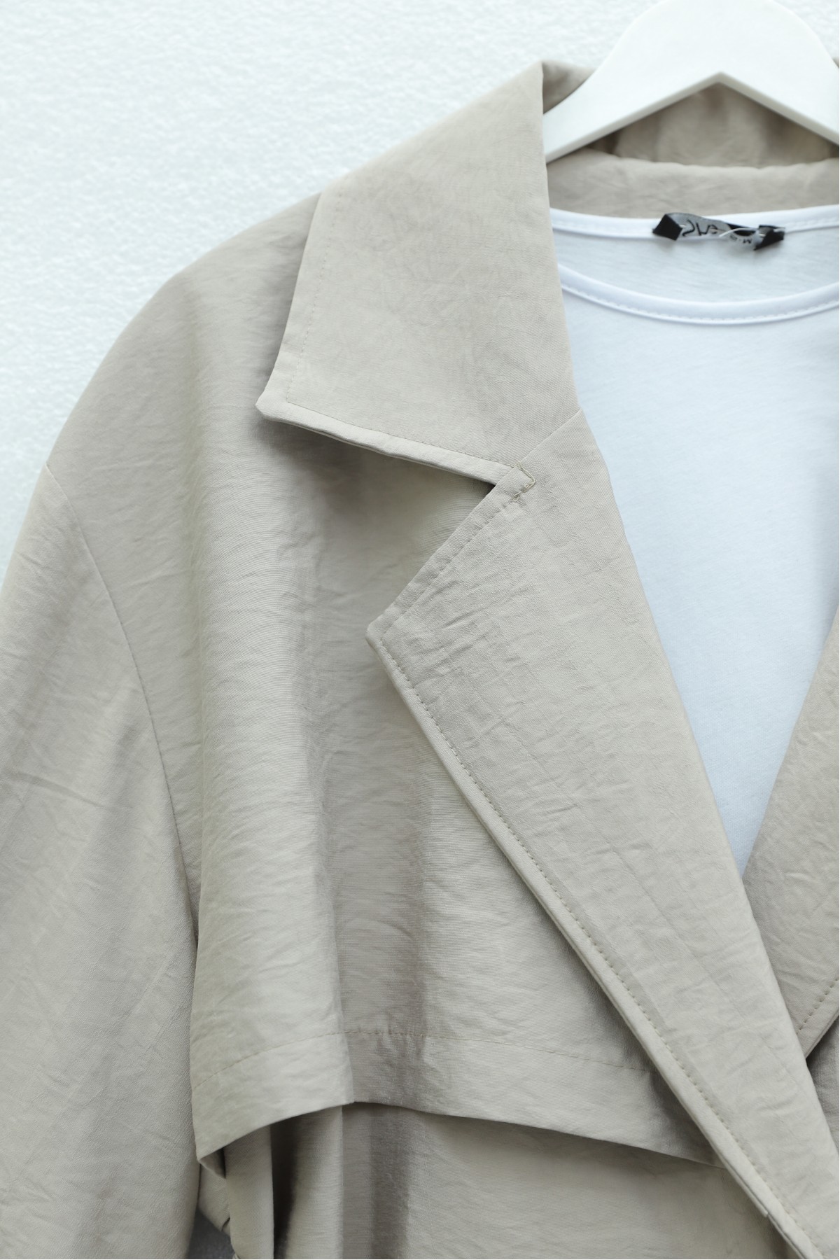 Trench coat made of polyester fabric with belt, pockets, and epauletted sleeves. -Stone
