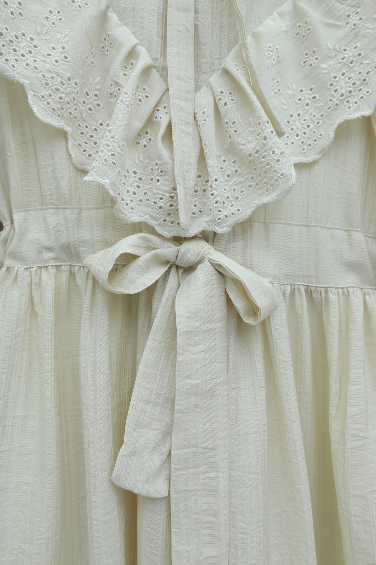 فستان مبطّن ومجعد بتفاصيل من الدانتيل عند خط العنق والخصر. -حجر