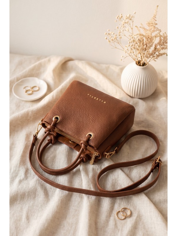 Multi-compartment shoulder bag with knot buckle and zipper and snap detail. -Snuff